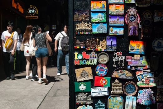 Vibrant collection of Macau-themed souvenirs with pedestrians on a sunny street.